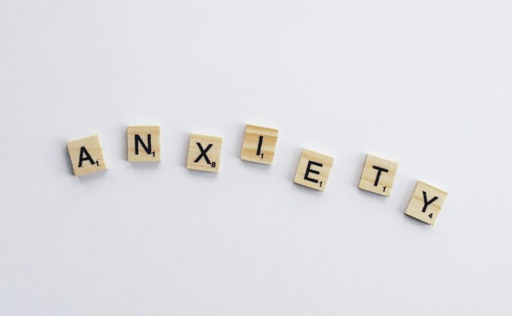 Wooden tiles on a white background spell anxiety, symbolizing mental health awareness.